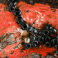 Print of a Kolanut with Black Seed Beads, Painted with Orange and Black Enamel Paint